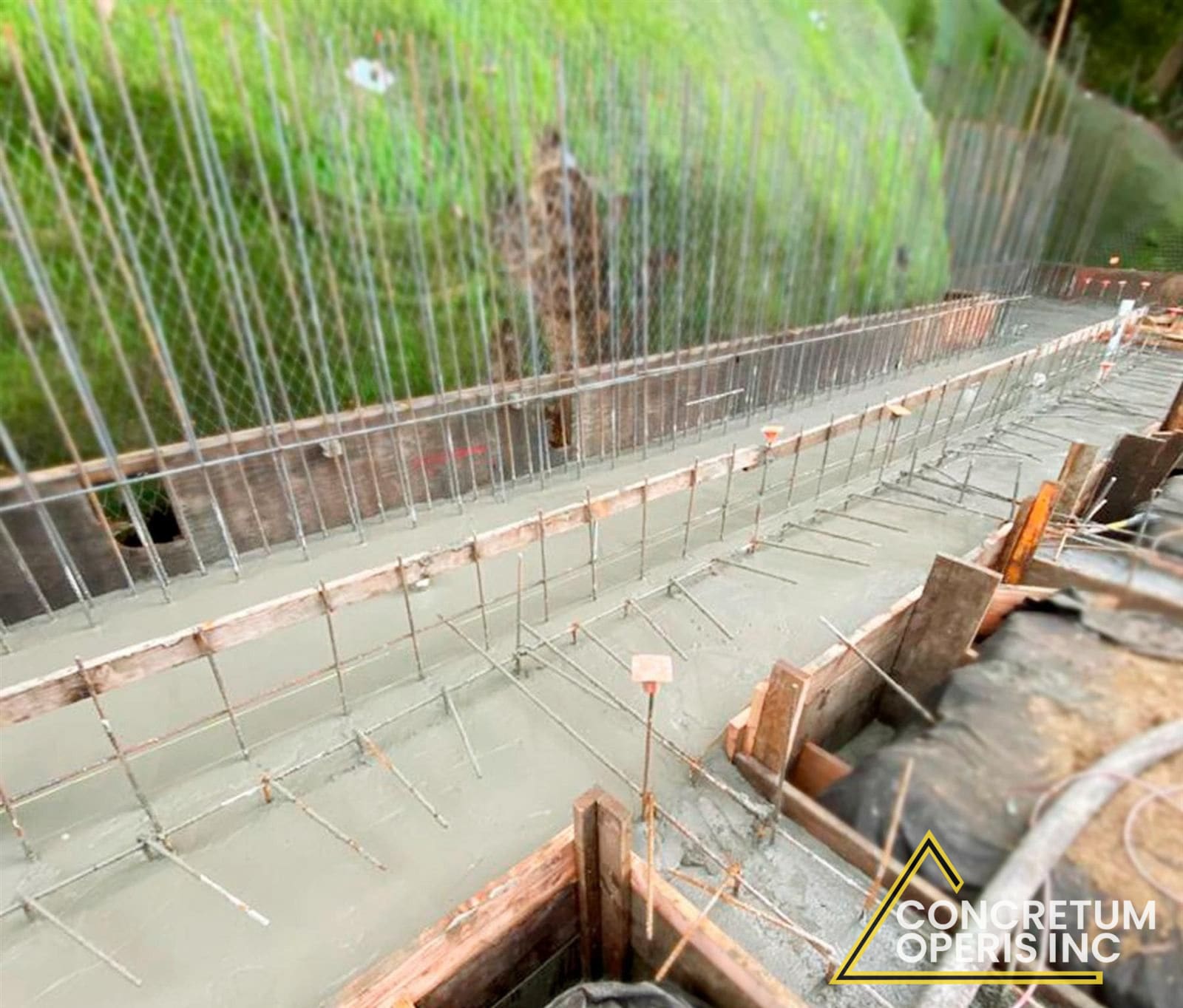 Aerial view of a rebar-reinforced concrete wall pour along a hillside in Richmond, CA